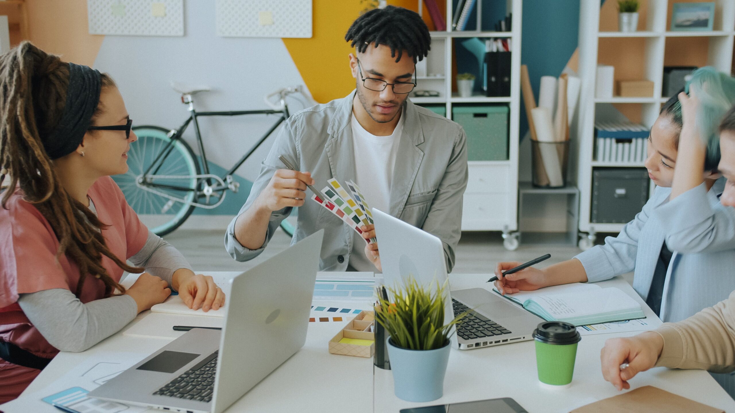 Diverse creative team discussing color samples during a meeting in a modern office.
